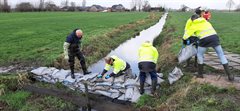 Afdammen sloot met zandzakken